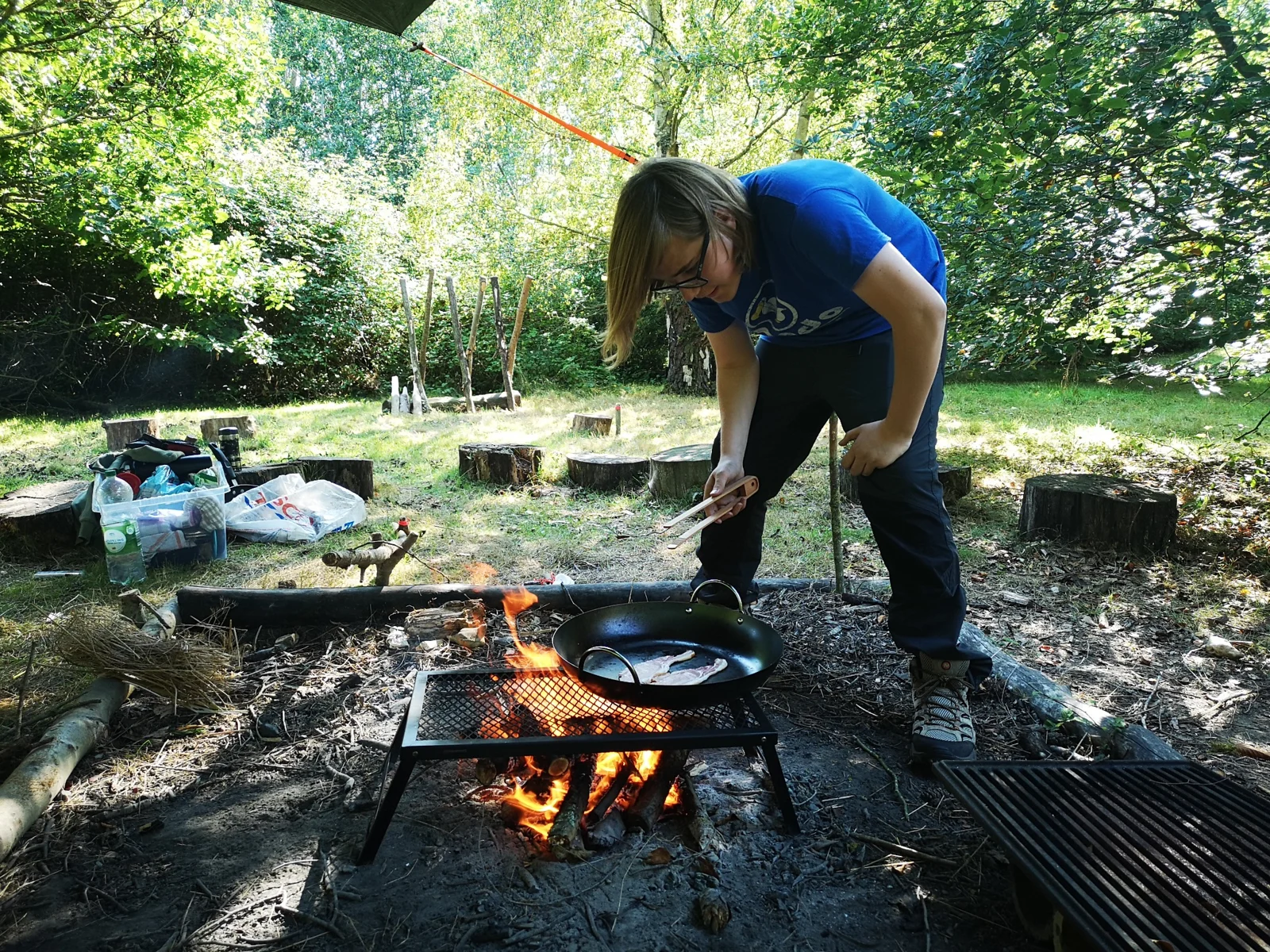 Preparing food over a woodland campfire