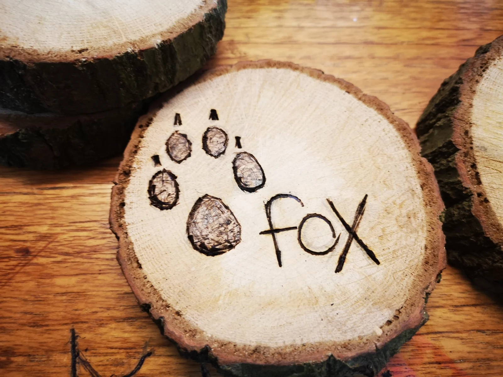 Fox tracking artwork on a wooden disc